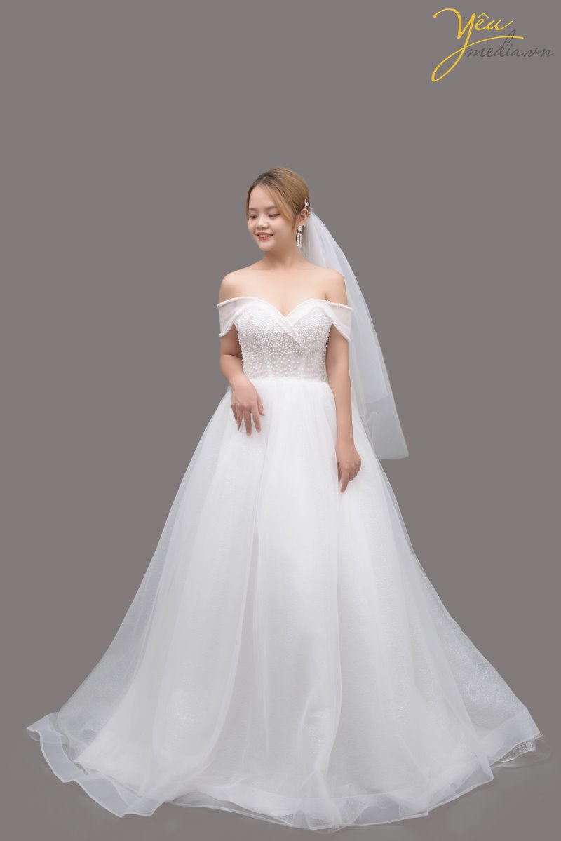 Váy cưới Meena với bờ vai hơi "trễ nải" nhưng vẫn tôn lên vẻ sang trọng và rực rỡ của cô dâu trong ngày cưới. Đây là 1 trong những mẫu váy được ưa thích nhất tại Yêu Media bởi vẻ kiêu sa và lóng lánh của nó khi xuất hiện trên lễ đường tràn ngập ánh sáng.