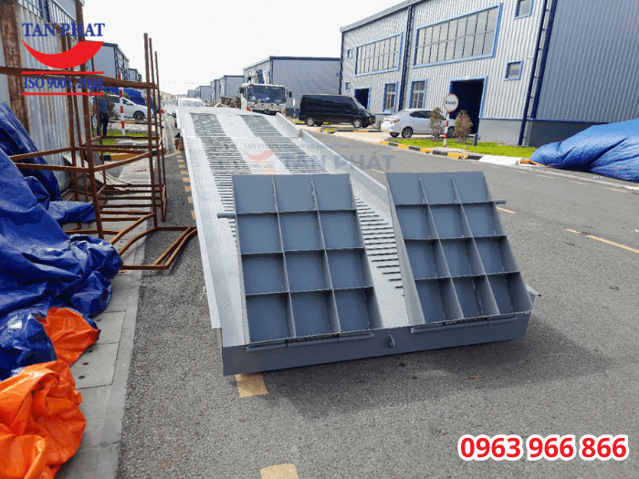 Mặt cầu chống trượt bằng tôn nhám, gia tăng với thép phi gân và thép vuông đặc. Ngoài ra, cầu sở hữu tấm tiếp đất giúp xe nâng di chuyển lên xuống dễ dàng