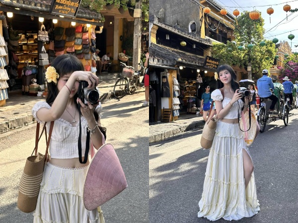 Chụp ảnh đứng với phụ kiện là máy ảnh và nón lá