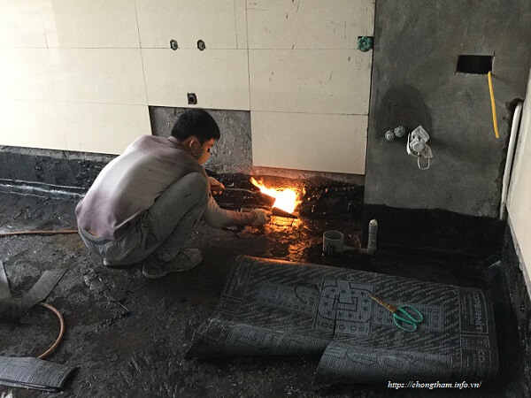 Công nhân đang dán màng khò chống thấm nhà vệ sinh