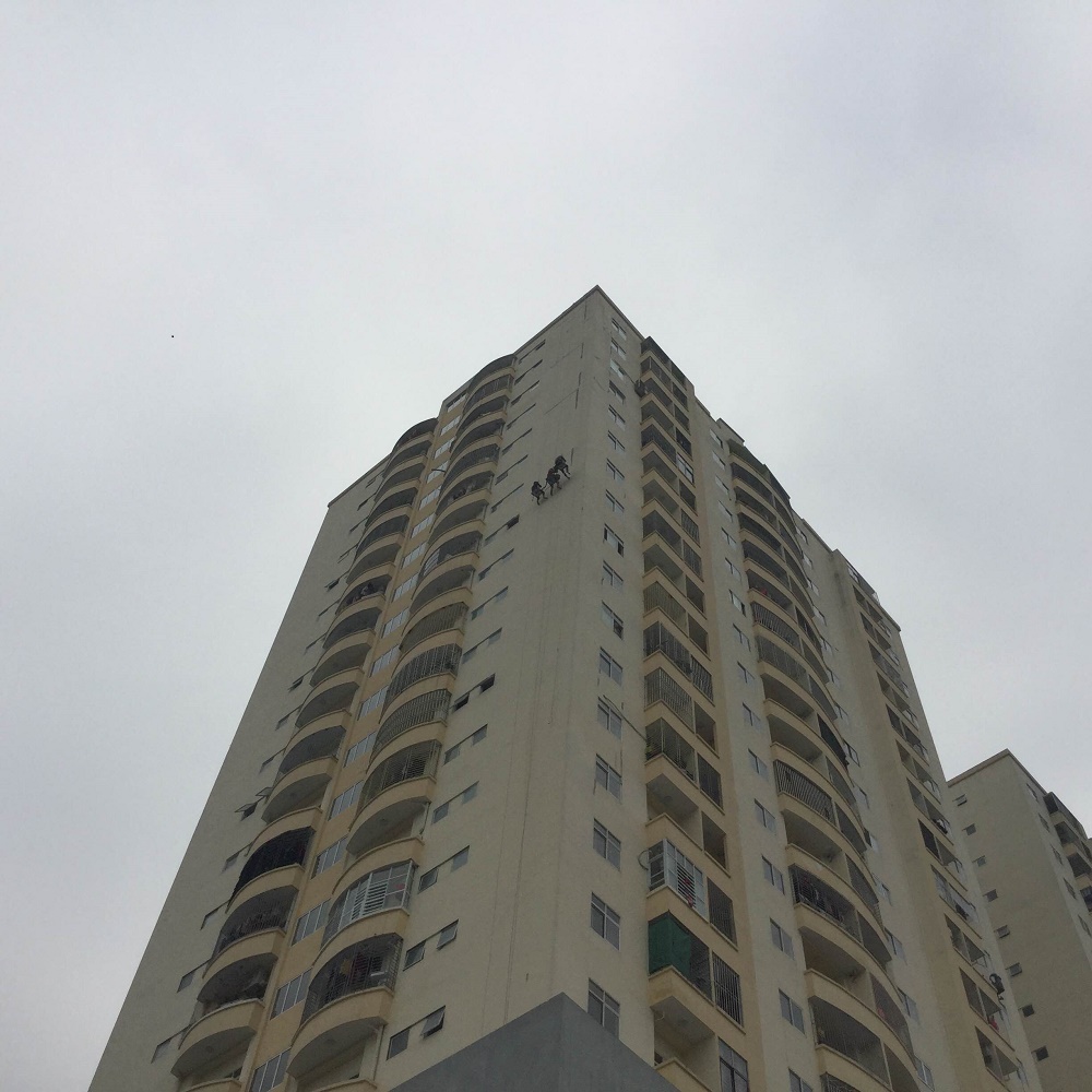 Công nhân đang đu dây để cắt rộng vết nứt theo biện pháp