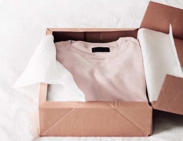 Bước 2 cách đóng gói hàng quần áo là bỏ áo vào hộp