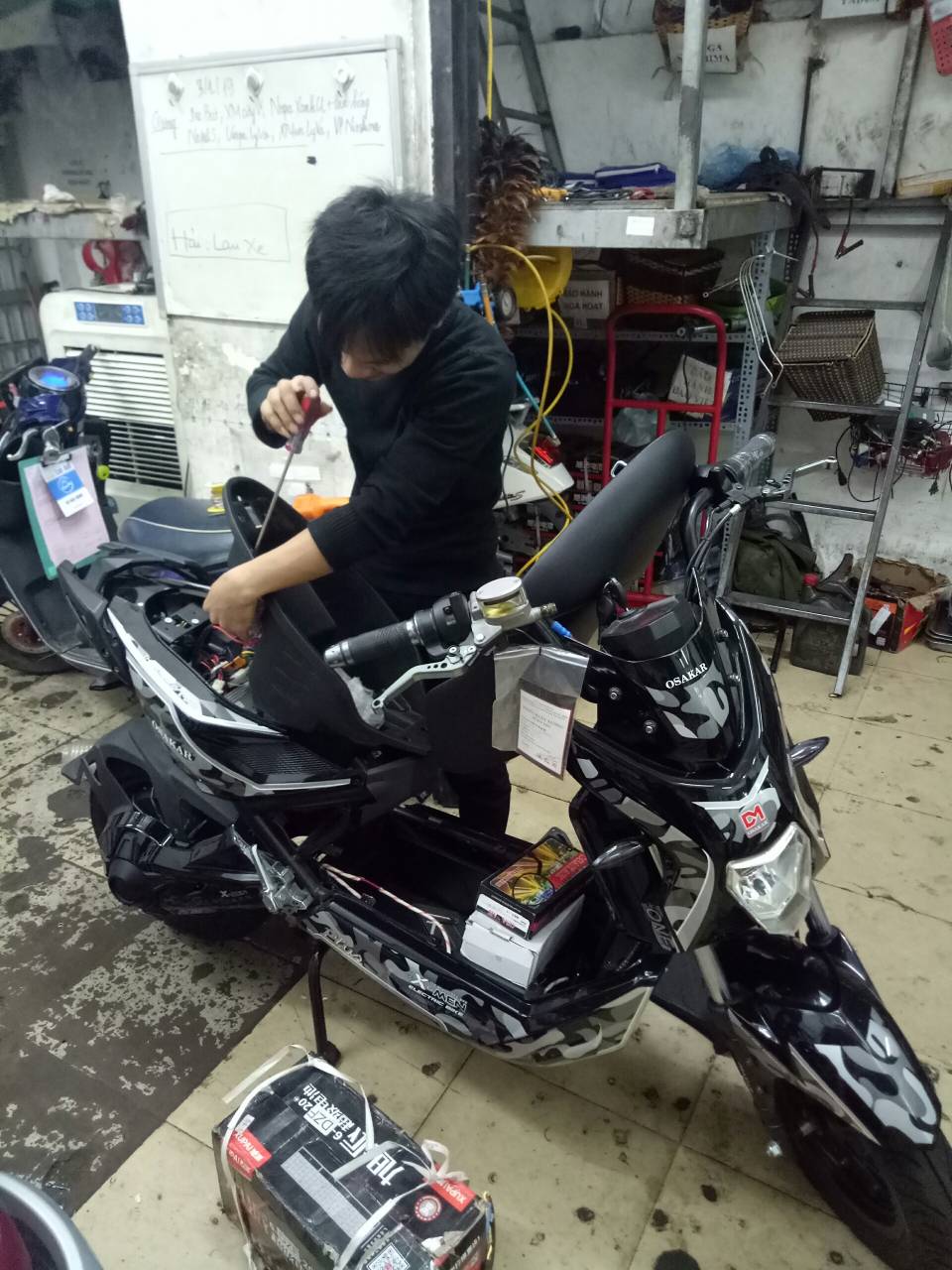 kỹ thuật viên Xe điện Lan Anh đang thay ắc quy cho xe điện Xmen