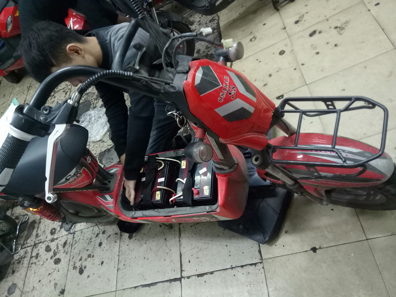 kĩ thuật viên đang lắp đặt ắc quy cho xe máy điện M133 Osakar