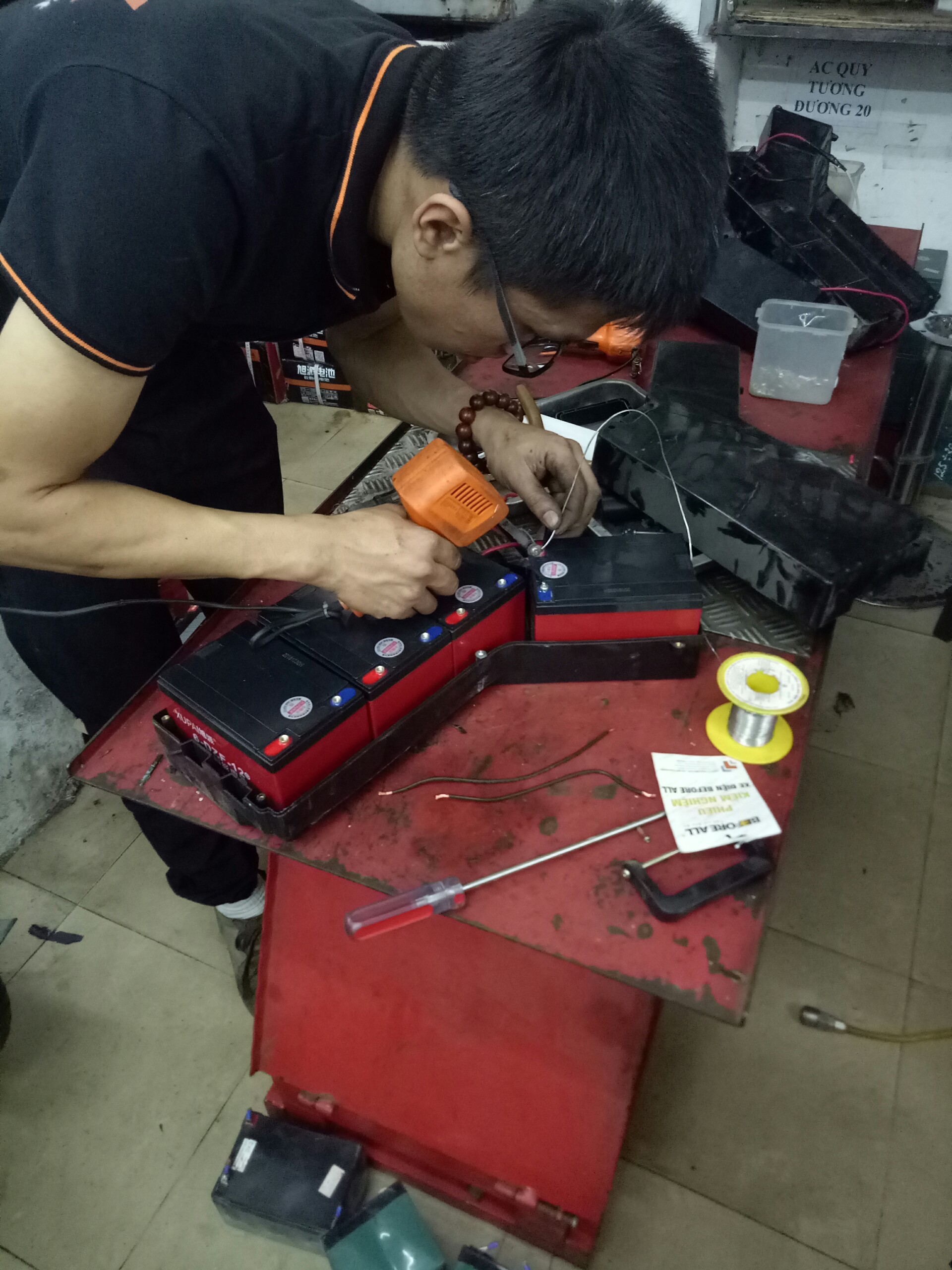 Kĩ thuật viên đang thay mới ắc quy xe đạp điện Nijia