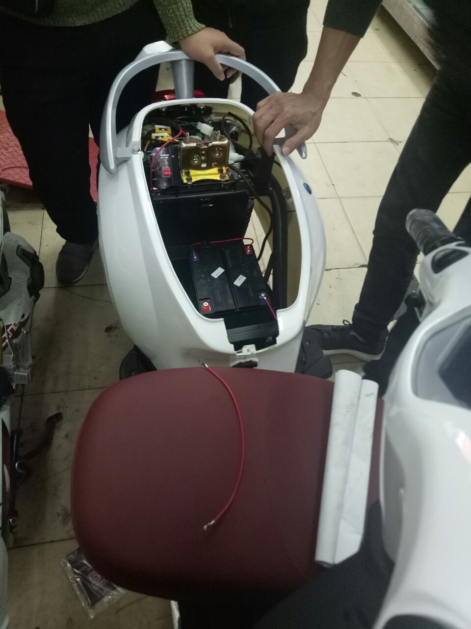 kĩ thuật viên đang thay ắc quy xe máy điện Vespa