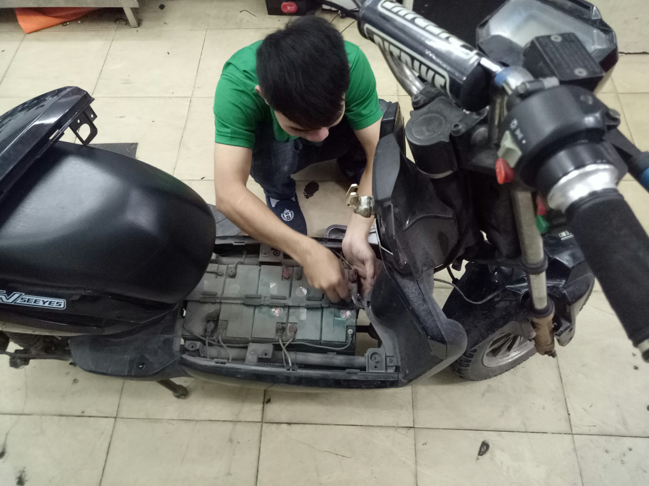 kỹ thuật viên thay ắc quy xe máy điện tại Xe điện Lan Anh