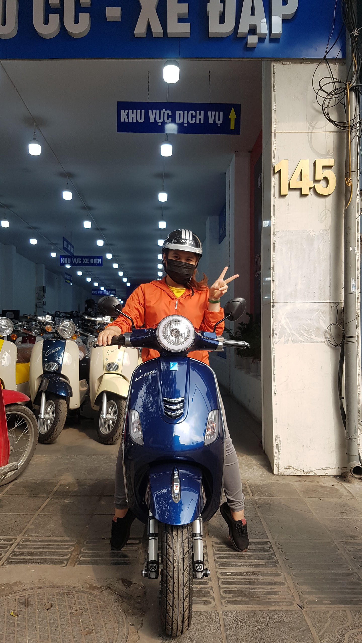 Nhân viên Xe điện Lan Anh đi giao xe máy điện Vespa màu xanh cửu long tận nhà cho khách