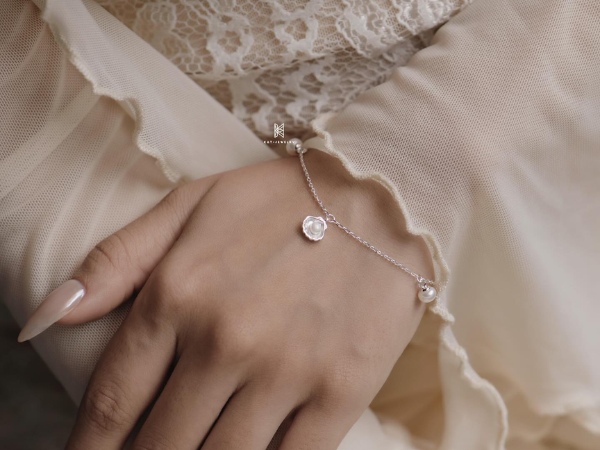 Lắc ngọc trai bạc kết hợp với charm trái tim tạo nên chiếc lắc tay hiện đại