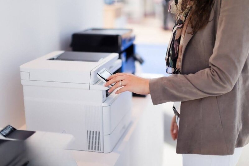 Một người phụ nữ đang tắt nút nguồn máy in và chờ khoảng vài phút rồi bật lại.