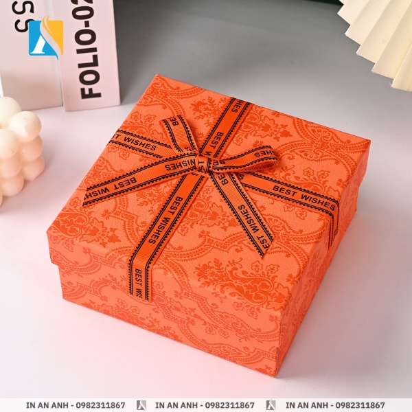 Hộp đựng quà màu cam với hoa văn và nơ ruy băng bắt mắt