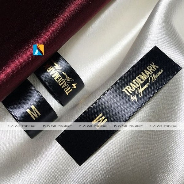 Mẫu tag quần áo bằng vải đen in chữ vàng