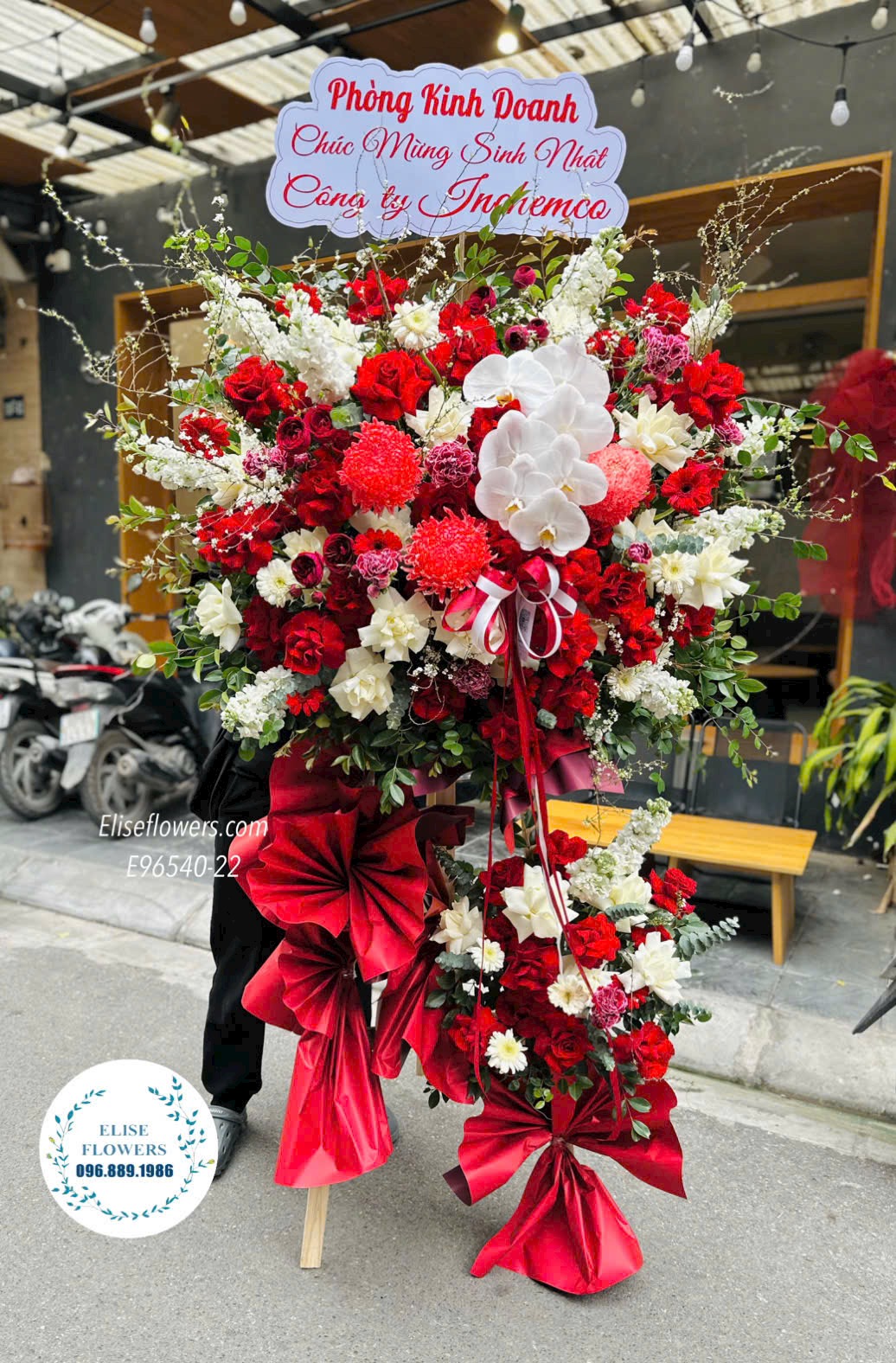 Kệ hoa chúc mừng kỉ niệm thành lập công ty. Kệ hoa tone đỏ rực rỡ, đại cát. Địa chỉ mua hoa uy tín Hà Nội
