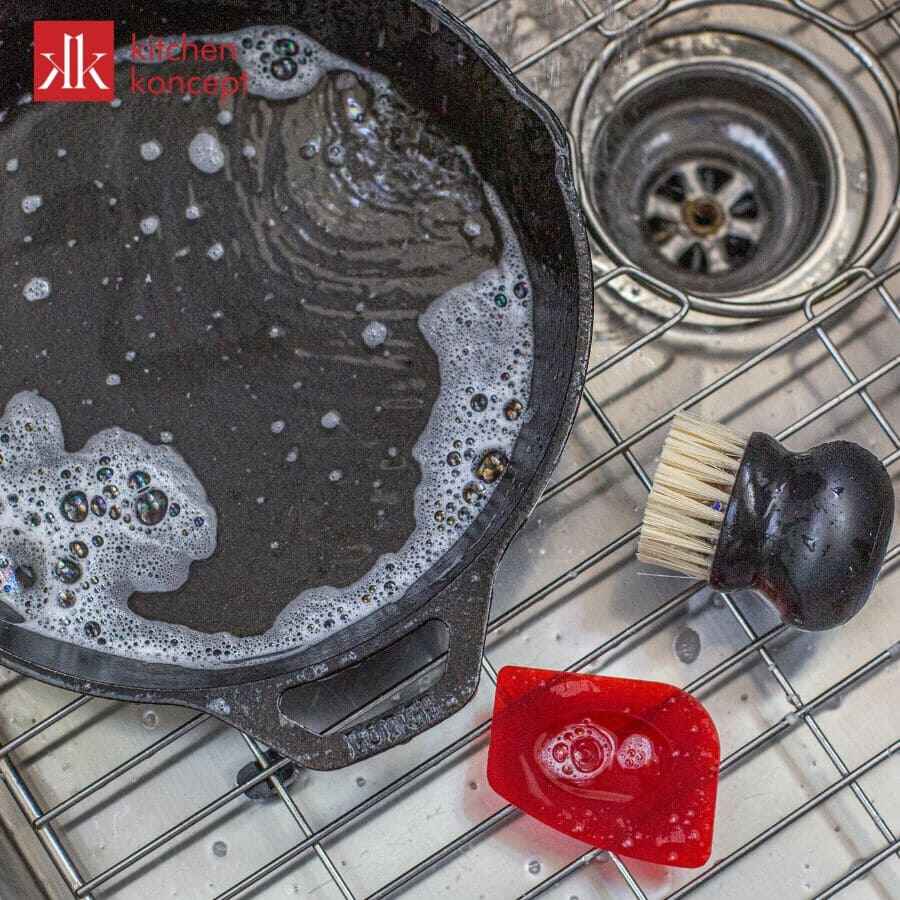 Rửa sạch chảo Lodge bằng nước ấm và xà phòng, bàn chải mềm