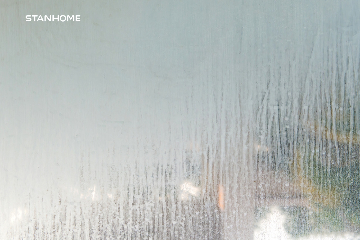 Những mảng bám trắng trên vách kính nhà tắm là dấu hiệu của cặn canxi