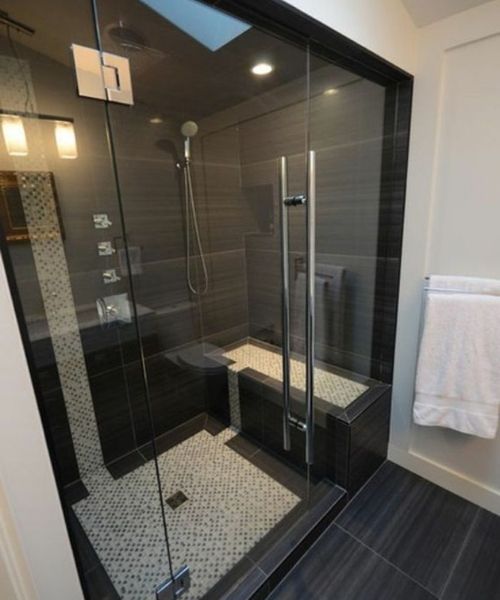 Sàn buồng tắm dùng gạch giả sỏi màu trắng để tạo sự khác biệt với tông màu đen của nhà tắm