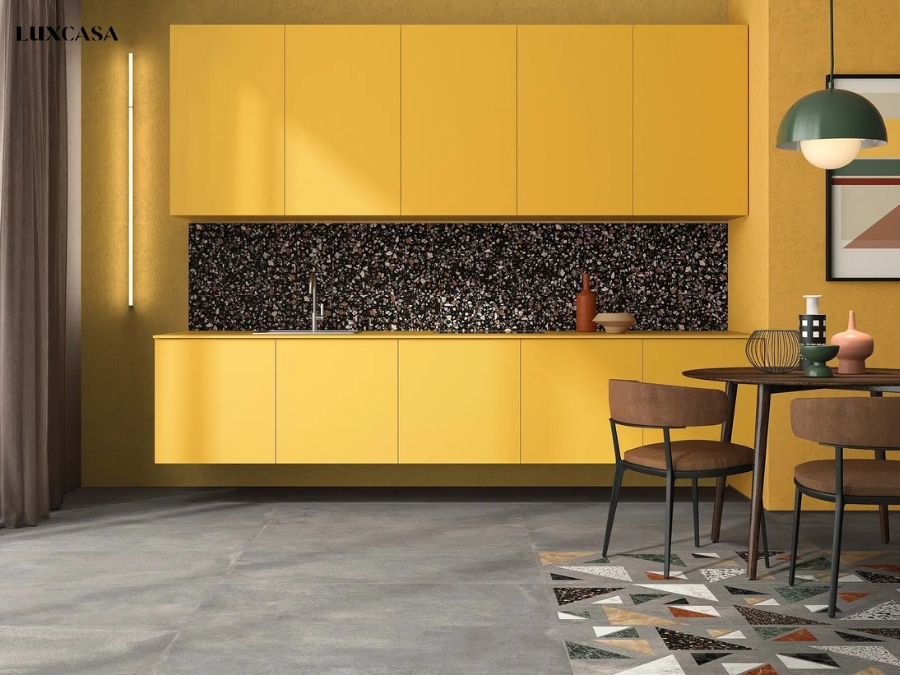 Tường bếp ốp gạch terrazzo màu tối trong một không gian màu vàng tạo nê sự tương phản cho căn phòng
