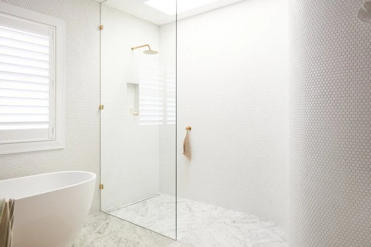 Một bức tường cong làm bằng những viên gạch tròn màu trắng trong phòng tắm