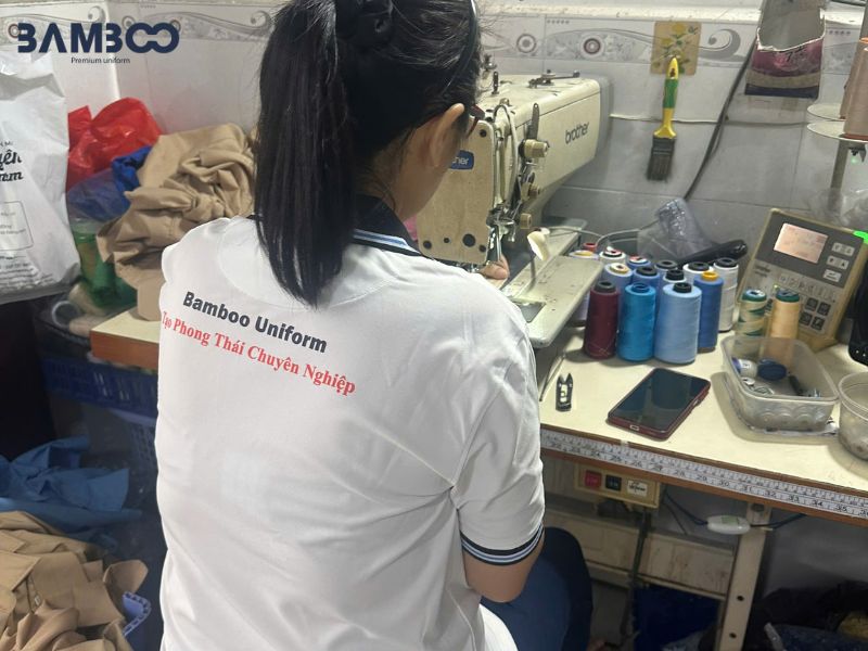 Quy trình may quần tây đồng phục xanh dương đậm gồm chọn vải cao cấp, cắt 2 đoạn, may tỉ mỉ, ủi ly và kiểm tra chất lượng