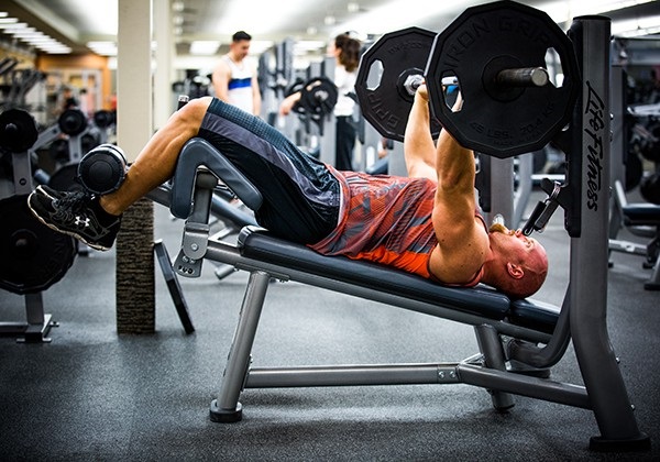 Bài tập đẩy tạ cùng với ghế dốc ngược trên máy