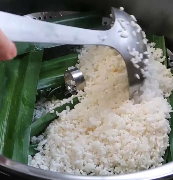 Xếp lá dứa vào xửng hấp rồi cho gạo vào