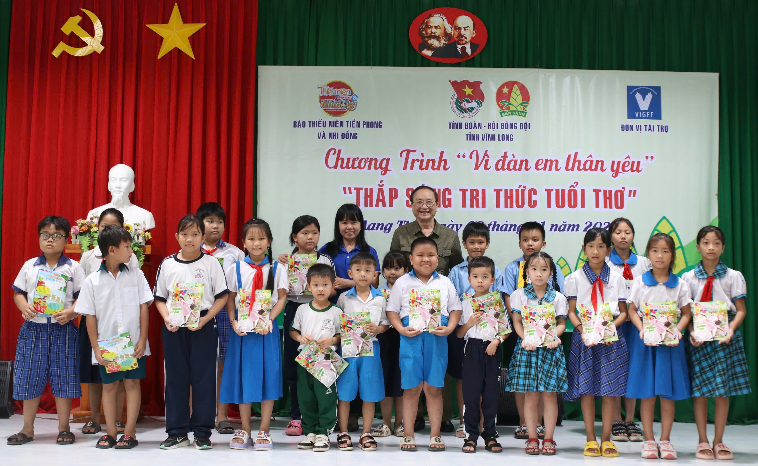 Nhà báo Ngô Hồng Phước - Ủy viên Ban Biên tập, Trưởng Văn phòng đại diện phía Nam báo TNTP&NĐ (áo xanh) và bác Đặng Tự Ân trao tặng quà, học bổng cho các bạn học sinh huyện Mang Thít.