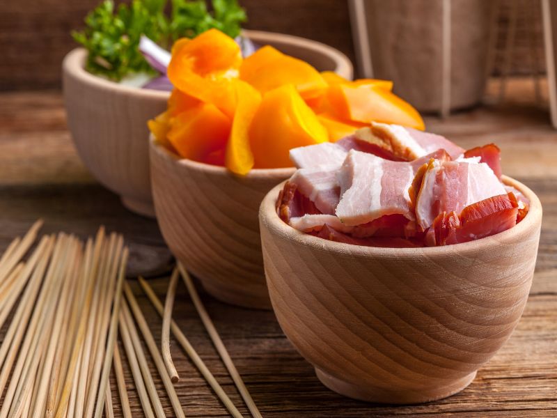 Xiên thịt lợn và rau củ vào que tre đã được ngâm nước