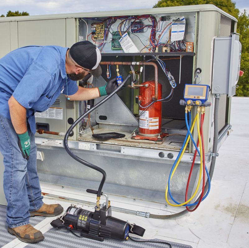 Kỹ thuật viên đóng van, tắt máy hút và theo dõi kim đồng hồ để kiểm tra rò rỉ