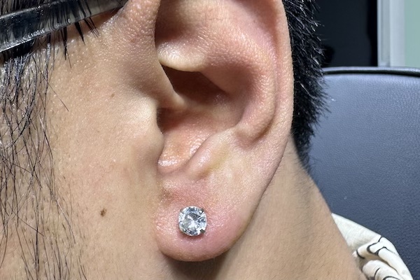 Hình ảnh khách nam xỏ khuyên tai - TinyBox xỏ khuyên