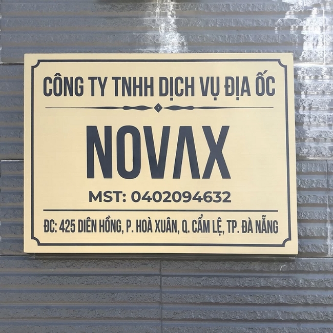 Một tấm biển công ty được được làm bằng inox ăn mòn với hoa văn và chữ độc đáo
