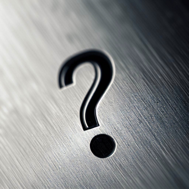 Cận cảnh bề mặt inox mờ với dấu chấm hỏi trên đó