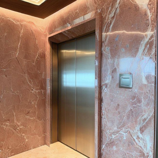 Cửa thang máy được ốp bằng đá granite hồng