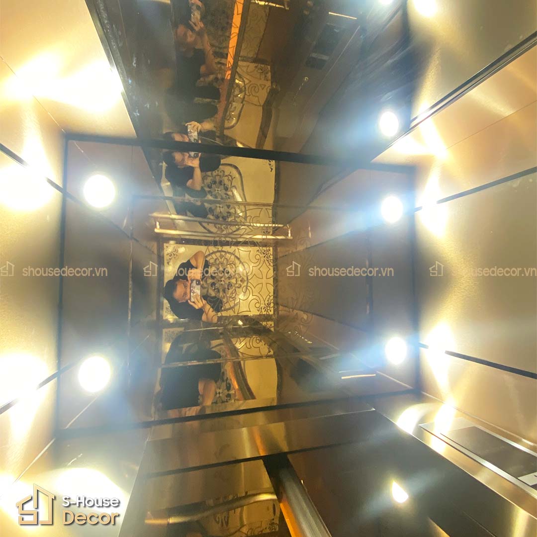 Trần cabin gương trà CNC ánh vàng nhạt với đèn LED âm trần.