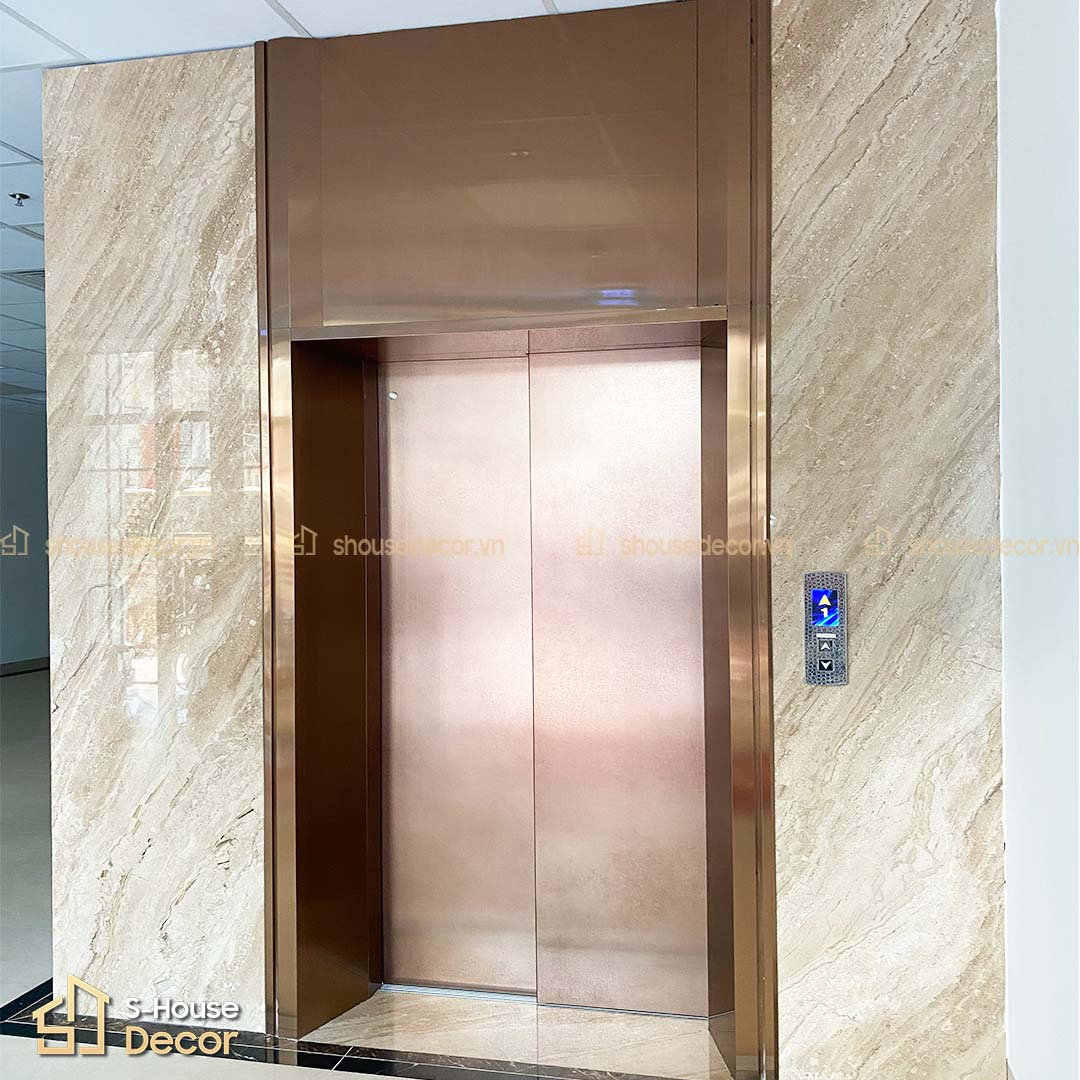 Mẫu hoàn thiện khung bao thang máy bản rộng phối màu vàng hồng ánh kim, tạo điểm nhấn cao cấp và tinh tế cho mặt tiền tầng.