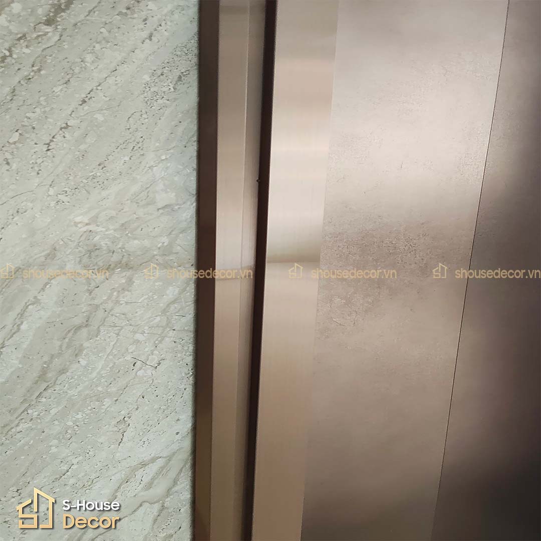 Bề mặt cửa tầng dán decal ánh kim sang trọng, kết hợp khung bao inox vàng hồng