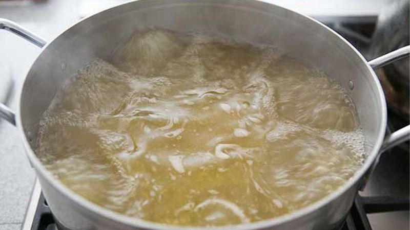 Ảnh 4: Đầu, xương lươn cho vào nồi với một chút muối để nấu nước dùng