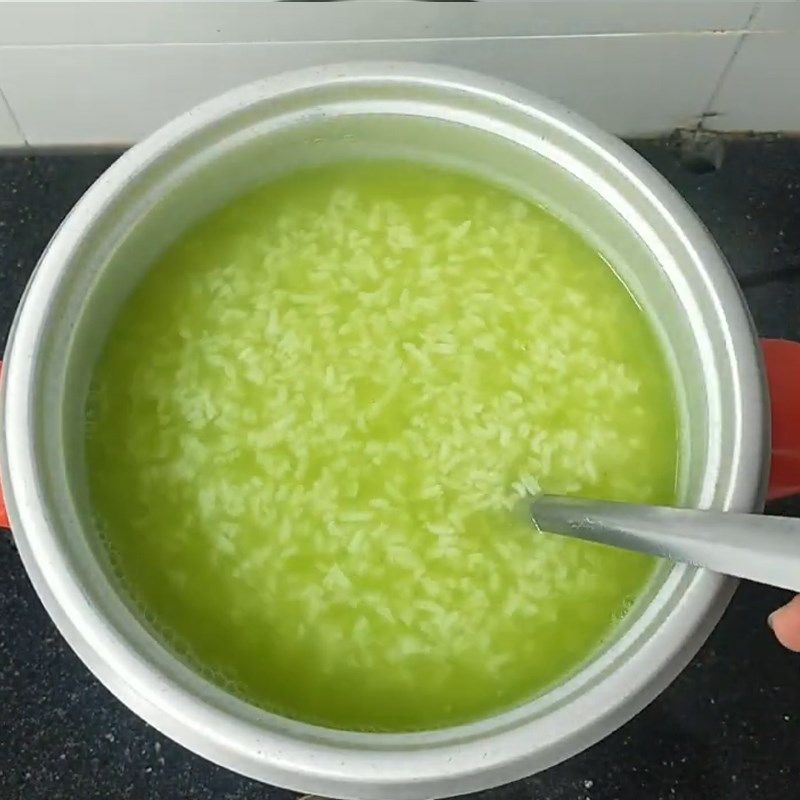 Thêm nước lá dứa vào, bạn sẽ thấy nồi cháo chuyển sang màu xanh nhẹ cực đẹp mắt
