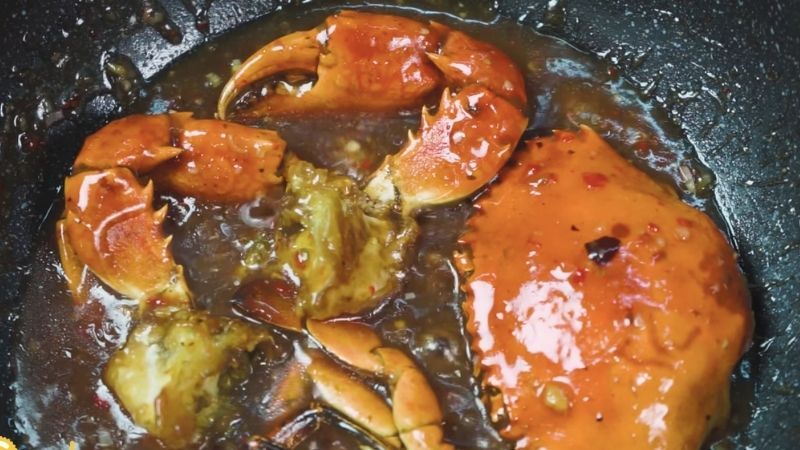 Ảnh 9: Cho cua đã chiên vào nồi để ngấm sốt me chua cay