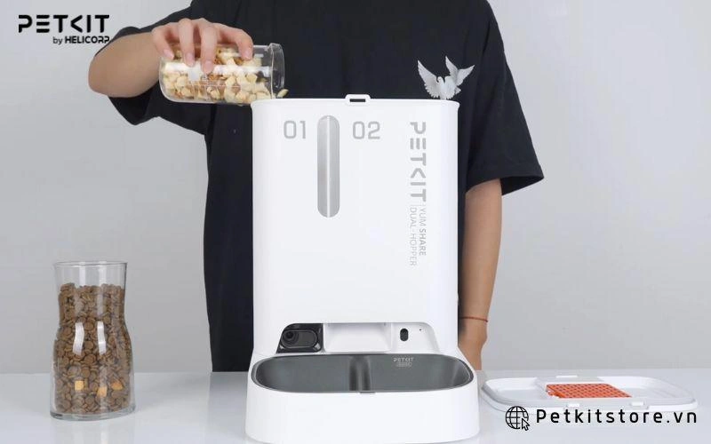 Cho các loại hạt vào hai ngăn thức ăn của máy cho mèo ăn