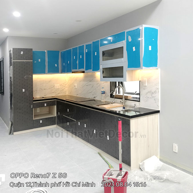 Tủ bếp hiện đại chữ L, gỗ công nghiệp An Cường, khung MDF chống ẩm phủ melamine, cánh MDF chống ẩm phủ acrylic, mặt bếp đá tự nhiên kim sa đen, ốp tường đá marble trắng vân mây - Hoàn thiện