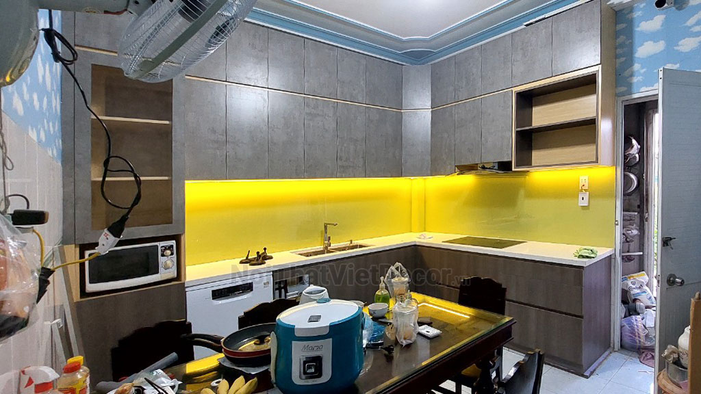 Tủ bếp hiện đại chữ L, tủ dưới nhựa phủ PVC, tủ trên mdf chống ẩm phủ melamine Thanh Thùy, mặt đá nhân tạo cao cấp Vicostone BQ1080, ốp tường kính cường lực 8mm sơn màu - Hoàn thiện