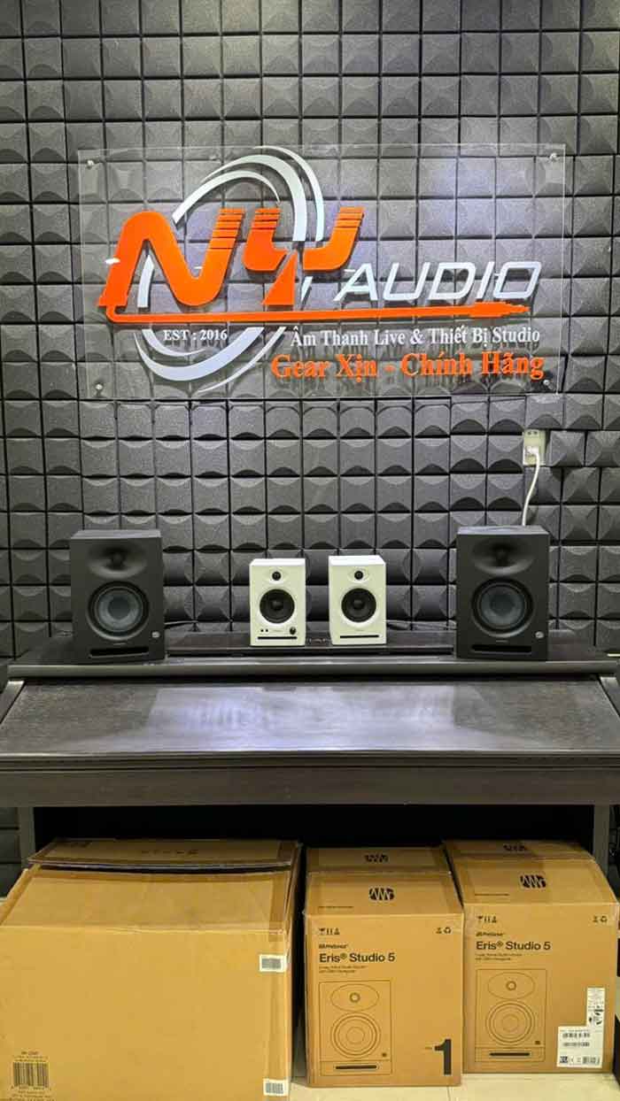 Review Loa Kiểm Âm Ortizan C7 hình đang được chụp miêu tả trong phòng thiết bị âm thanh, có treo logo lớn NY Audio – một đơn vị chuyên cung cấp thiết bị phòng thu và âm thanh live