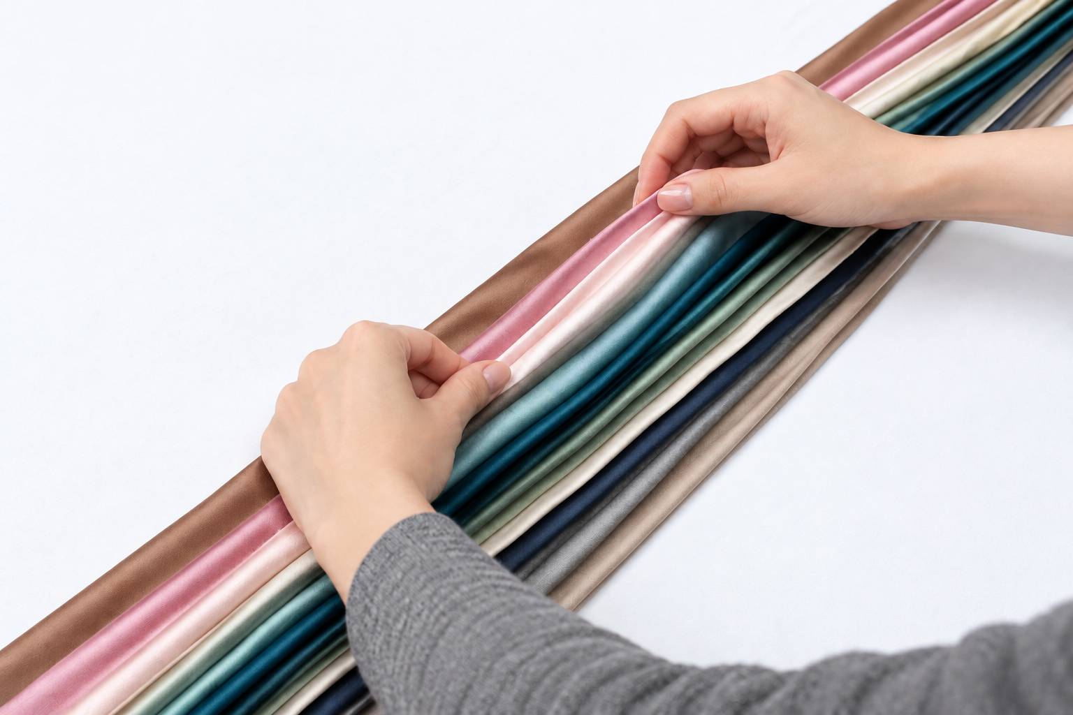 Bàn tay chạm vào các cuộn vải Tencel nhiều màu