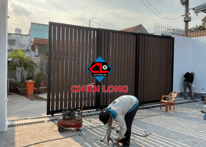 Cổng xếp lùa 3 lớp ốp nhựa giả gỗ hiện đại dùng motor tự động - xu hướng mới cho các công trình hiện nay