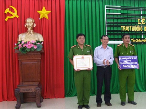 Nguyễn Hữu Ngân, phó giám đốc Sở Nội vụ; phó chủ tịch Hội đồng thi đua tỉnh trao bằng khen và tiền thưởng cho tập thể Công an huyện Tân Châu.
