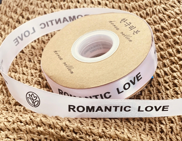 Ruybang vải kt 2.5cmx 35m - chữ ROMANTIC LOVE màu đen-nền HỒNG.