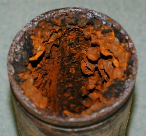 Hình Ống sprinkler thép (đường kính 4 inch) bị ăn mòn và rò rỉ, với nhiều mụn ăn mòn. MIC do vi khuẩn SRB là nguyên nhân chính.