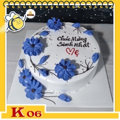 Bánh kem tặng khách hàng K06 với các cành hoa uốn lượn màu xanh dương trên mặt bánh nền màu trắng