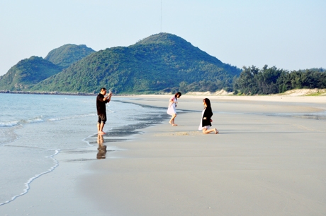 Du khách dạo chơi bên bờ biển Minh Châu