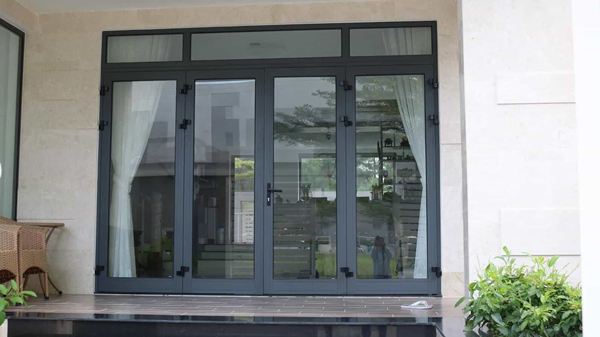 Một mẫu cửa nhôm Xingfa 2 cánh màu ghi xám lắp đặt cho một biệt thự.